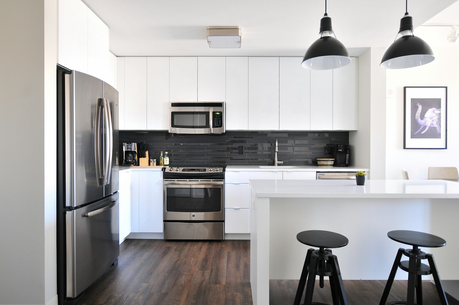 A bright home kitchen fitted with a refurbished microwave, oven, and refrigerator