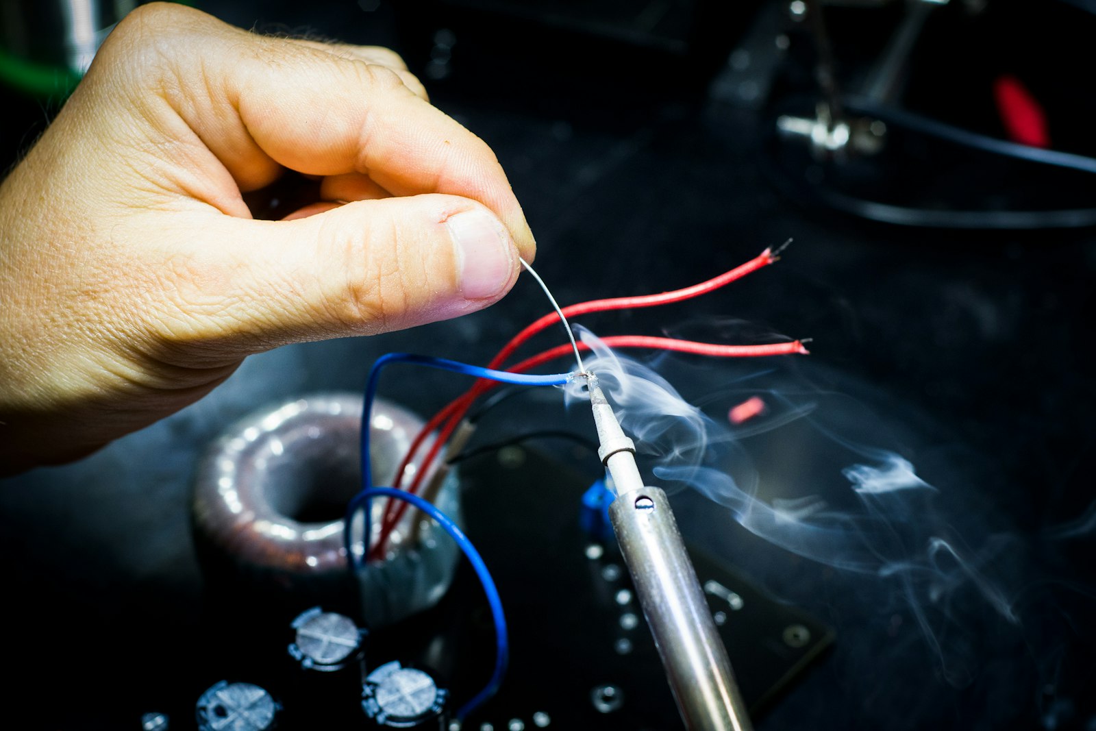 A technician repairing the internal wiring of a household appliance at a workbench